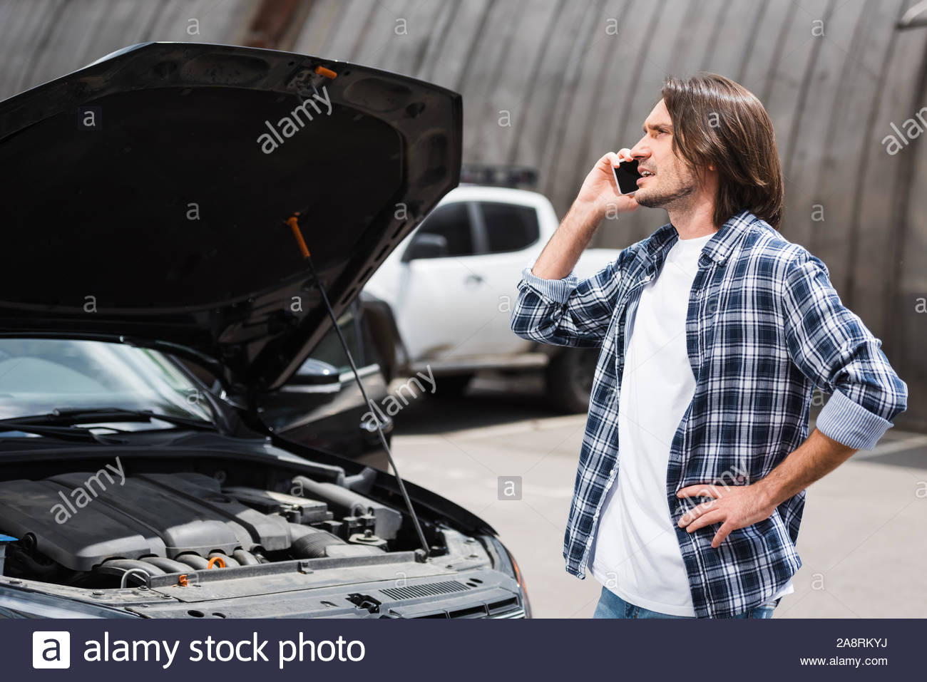 Man Talking On Smartphone Standing Near Broken Auto With in dimensions 1300 X 957